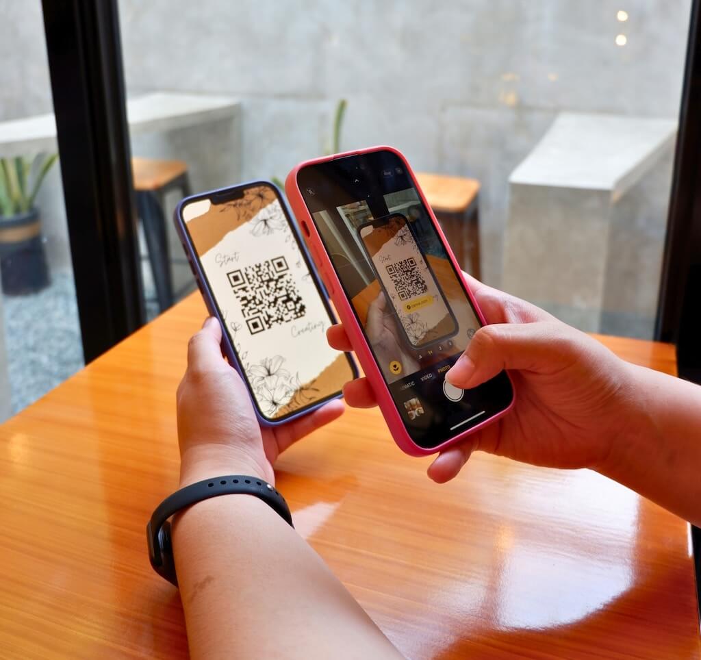Somebody using a phone to read a QR from another phone