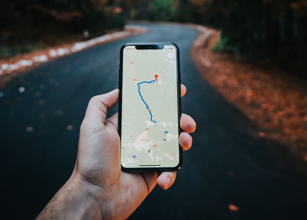 Hand holding a phone with a maps app running